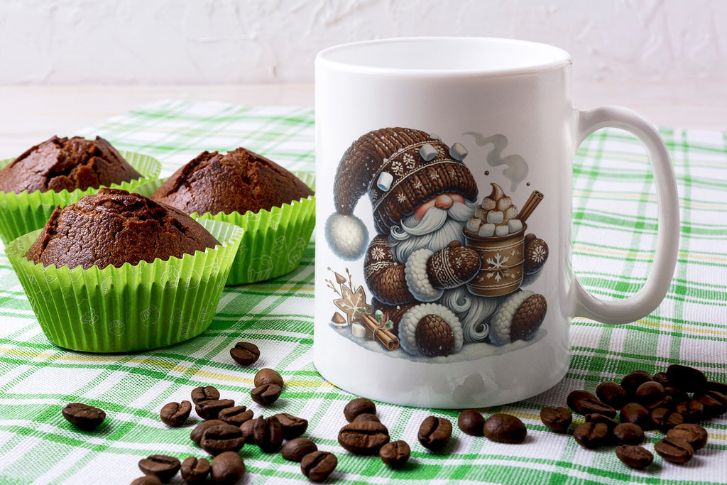 Mug with a gnomes design surrounded by chocolate muffins and coffee beans on a checkered tablecloth.