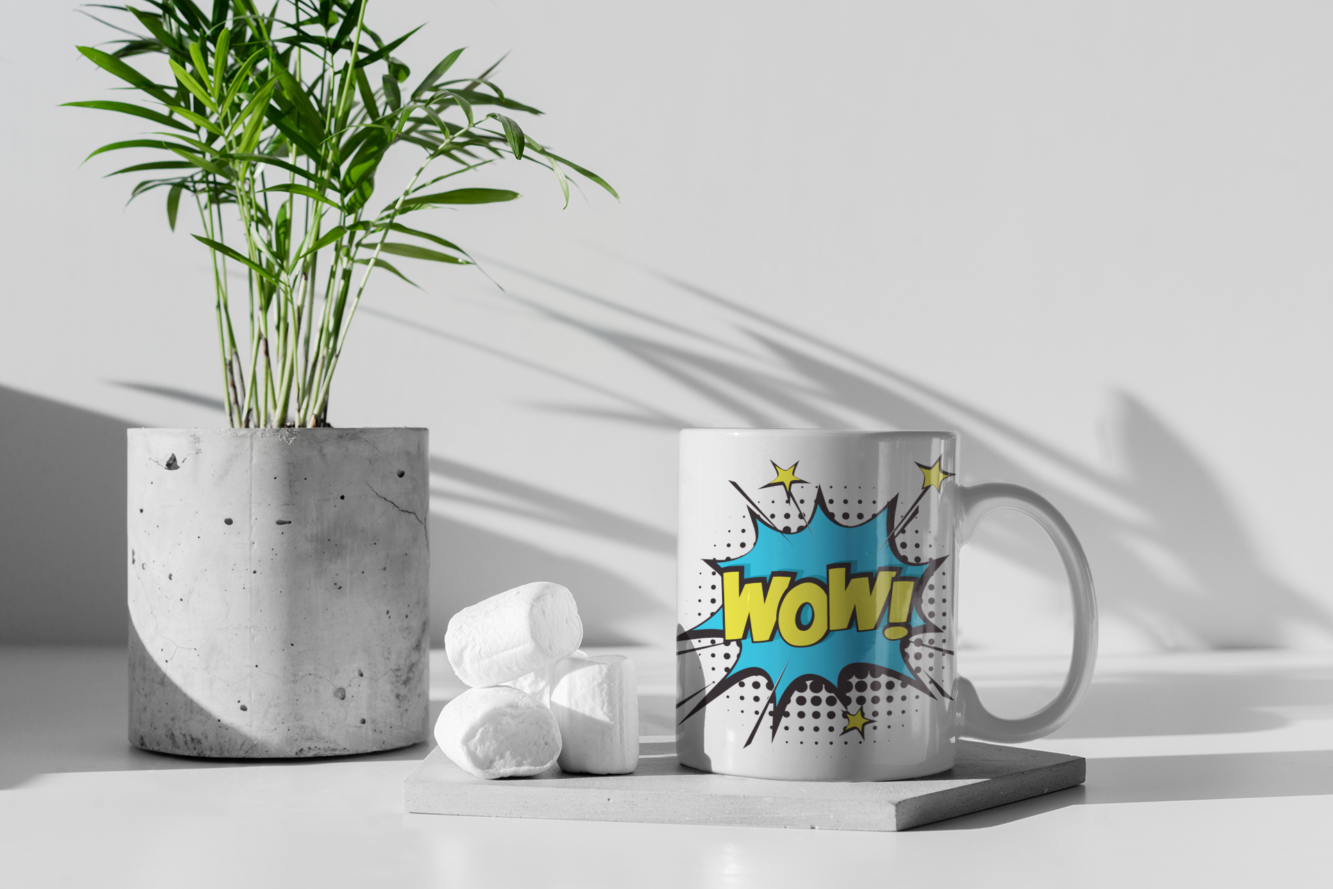 Mug with 'Wow' design next to a plant and decorative items on a light surface.
