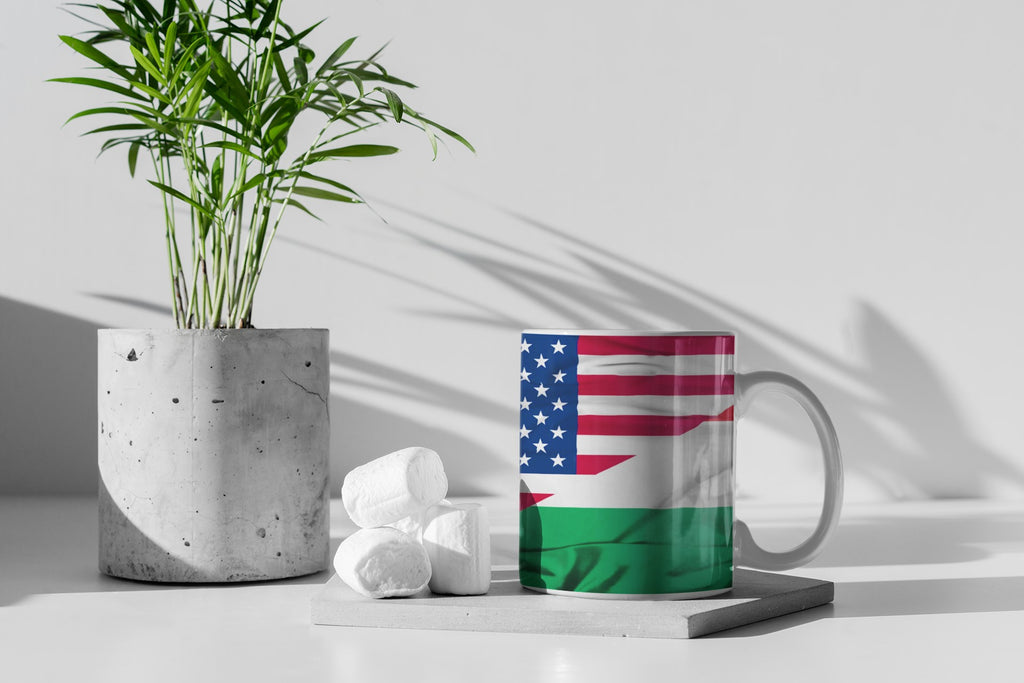 Mug with a flag design on a white surface with a plant and decorative items.