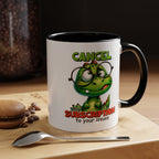 Mug with cartoon dinosaur design and text on a wooden surface with coffee beans and a macaron.