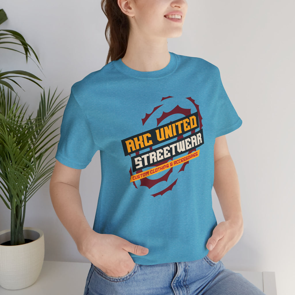 Person wearing a blue t-shirt with 'RKC United Streetwear' design, standing indoors.