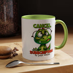 Mug with cartoon dinosaur design and text on a table with coffee beans and a macaron.
