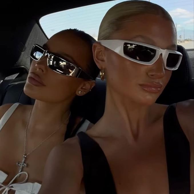 Two women wearing sunglasses inside a car.