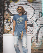 Man wearing a 'Bad Taste' t-shirt in front of a graffiti-covered wall