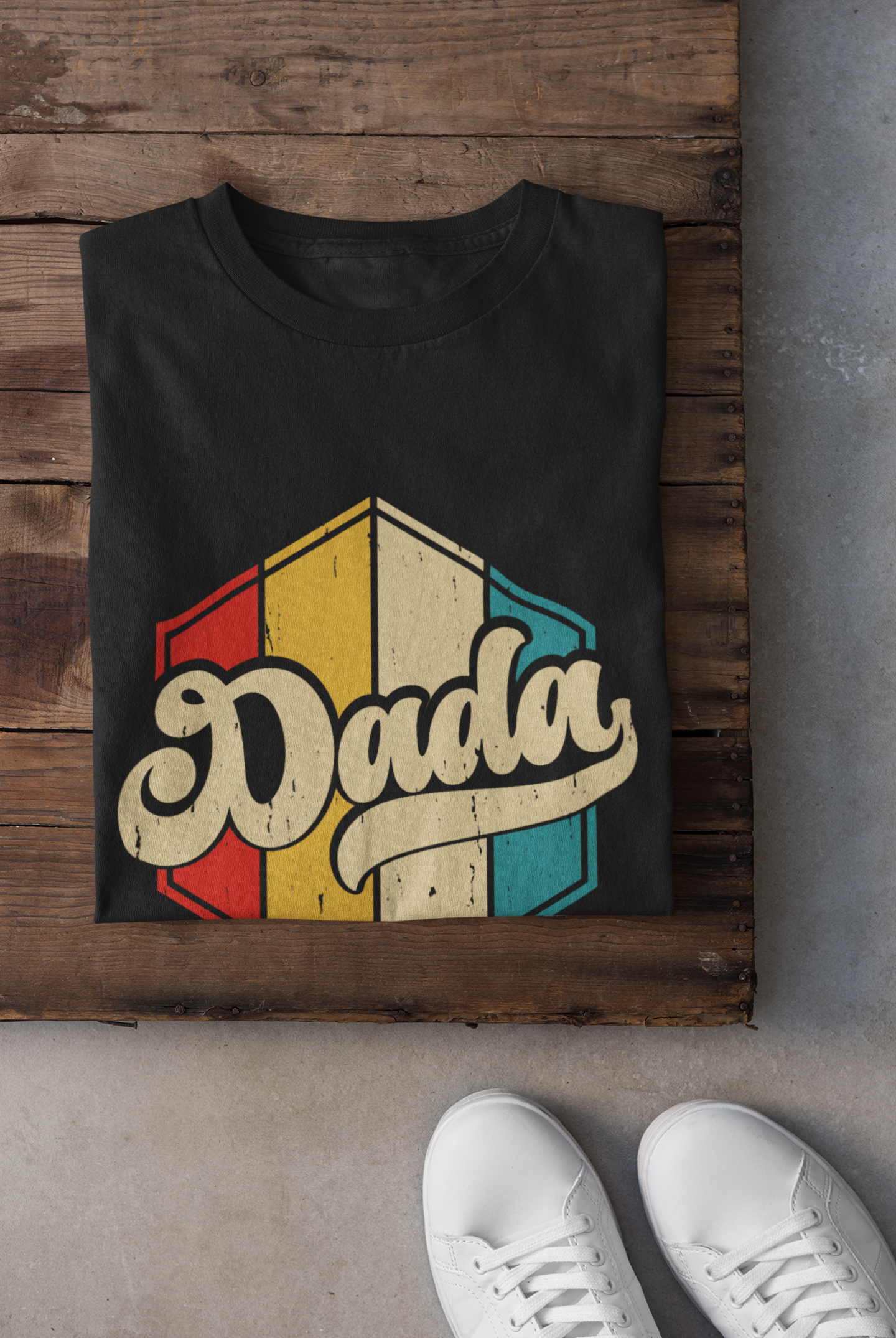 Black t-shirt with 'Dada' design on a wooden surface