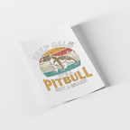 A printed poster or art print shown at an angle on a light gray background. The design features a pitbull illustration over a retro sunset and map-style graphic with the text 'KEEP CALM IT'S A PITBULL NOT A SHARK'.