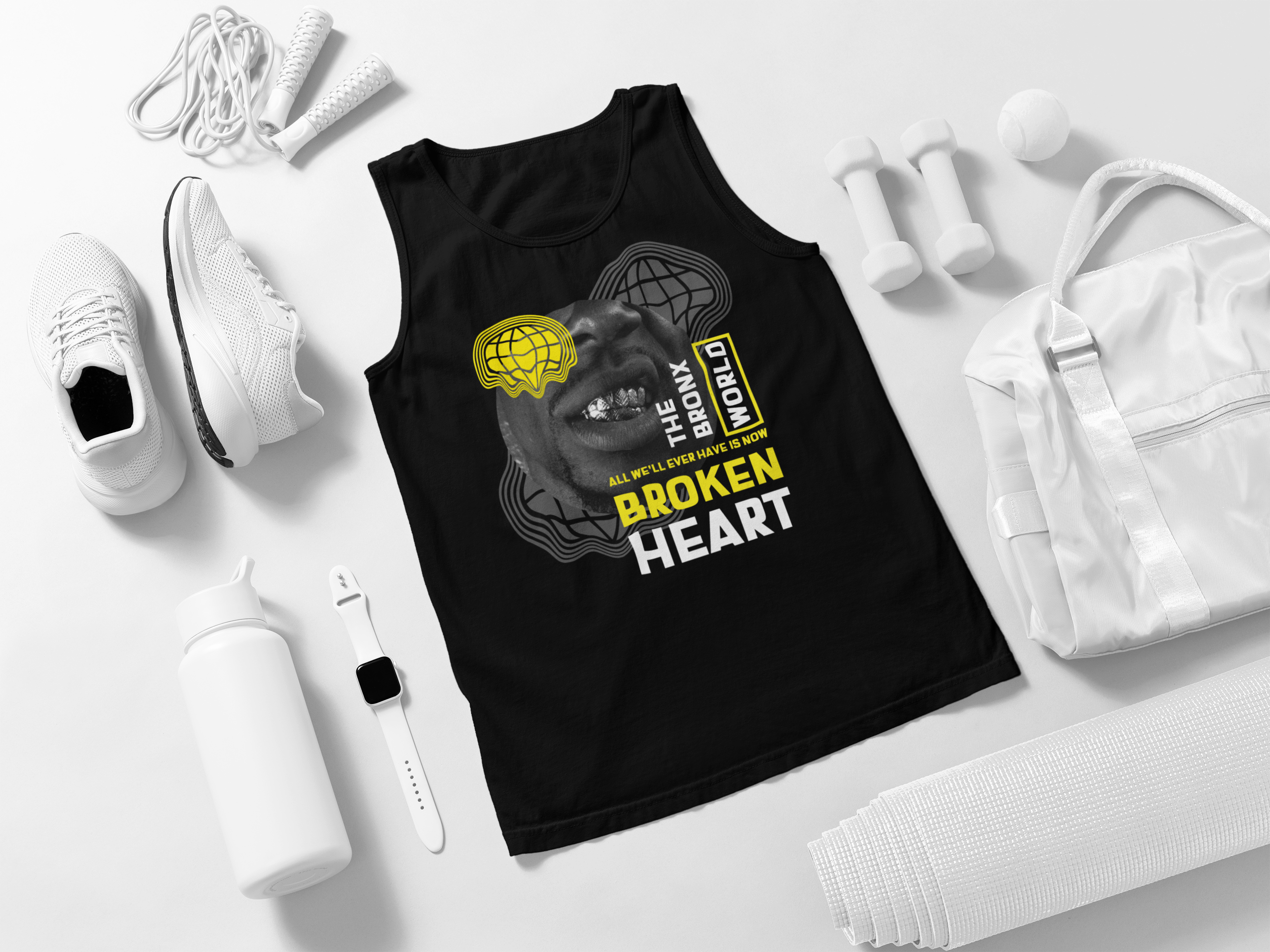 Black tank top with graphic design and text on a white surface with accessories.