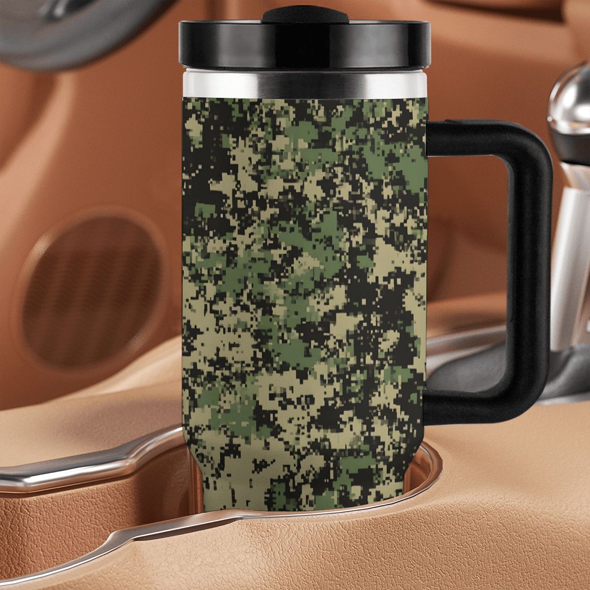 Camouflage-patterned travel mug with black handle on a brown leather surface.
