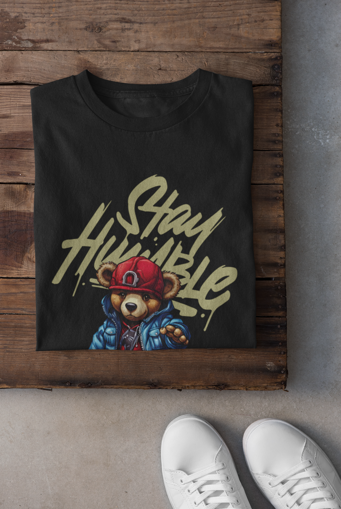 Black t-shirt with bear graphic and 'Stay Humble' text on a wooden surface.