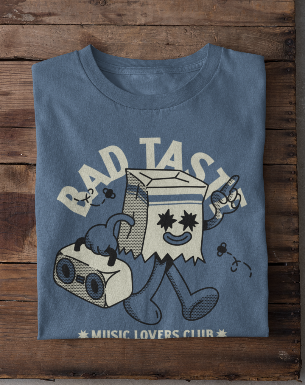 Blue t-shirt with cartoon character and text on a wooden surface