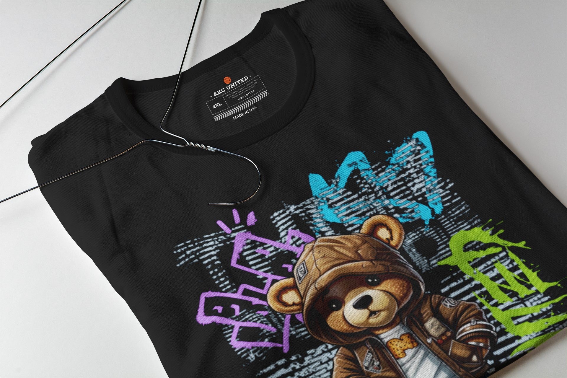 Black t-shirt with colorful graphic design of a bear and text on a white surface