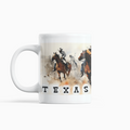 A white ceramic mug featuring a printed graphic of a Western-themed rodeo scene with horses and riders, and the word 'TEXAS' printed below in black block letters.