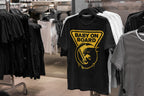Black t-shirt with yellow graphic and 'Baby on Board' text in a clothing store.