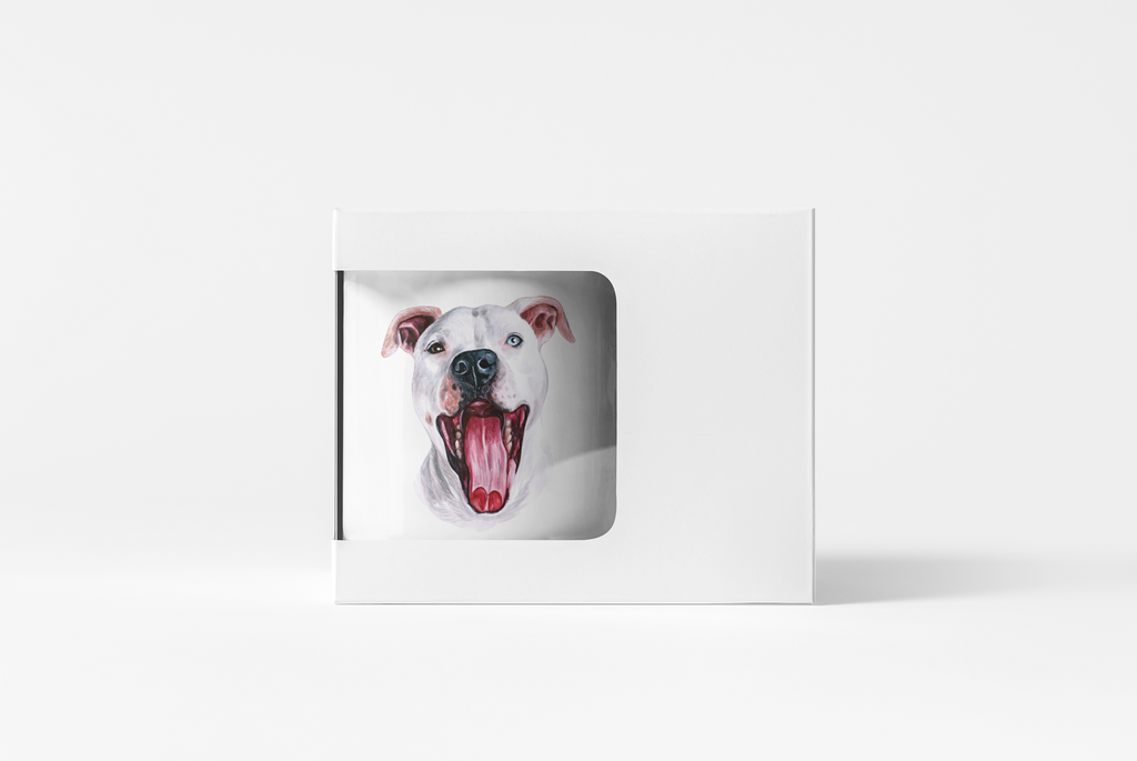 A white square gift box with a die-cut window displaying a painted portrait of a white dog with its mouth open, set against a clean white background.