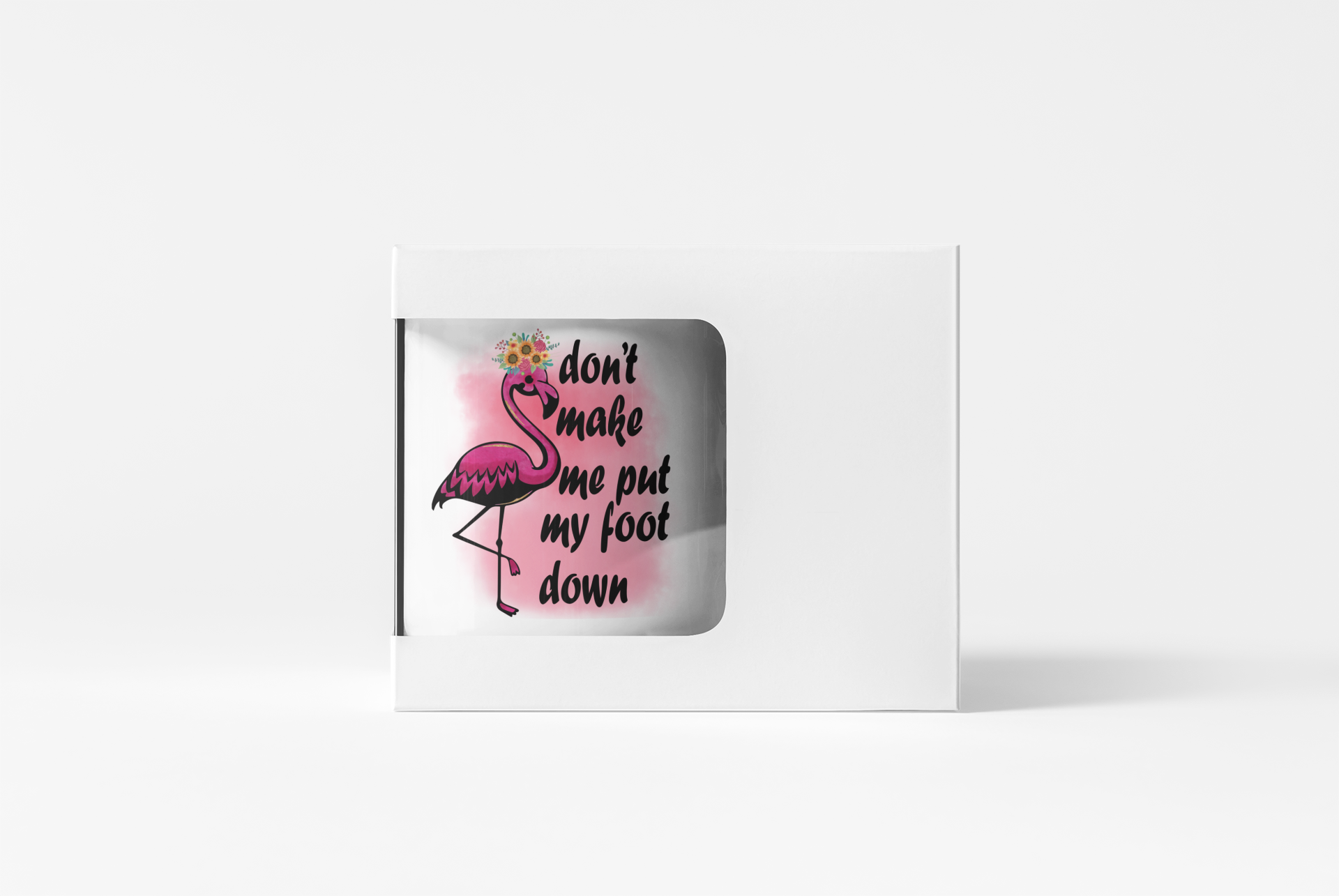 A white square mug or cup shown from the side with a clear window, revealing a printed design of a pink flamingo and the phrase 'don't make me put my foot down' on a light gray background.