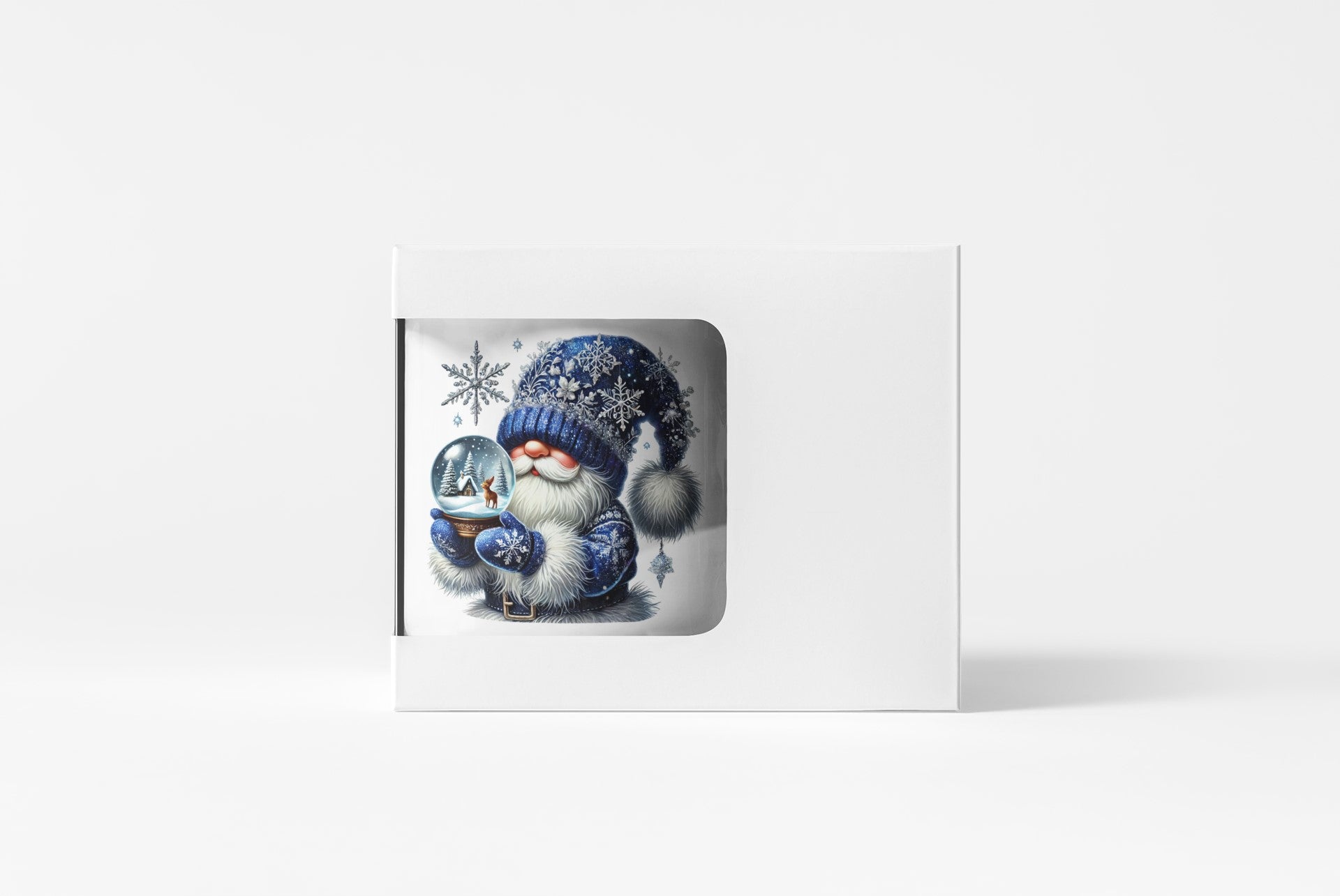 A white rectangular gift box or card holder with a die-cut window showing a winter illustration of a gnome in a blue knit hat and scarf holding a snow globe, set against a clean white background.