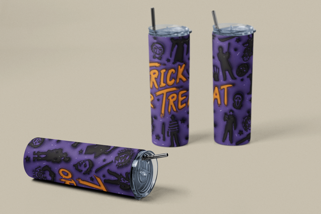 Three purple Halloween-themed tumbler cups with straws on a beige background. One cup is lying down, and two are standing upright.