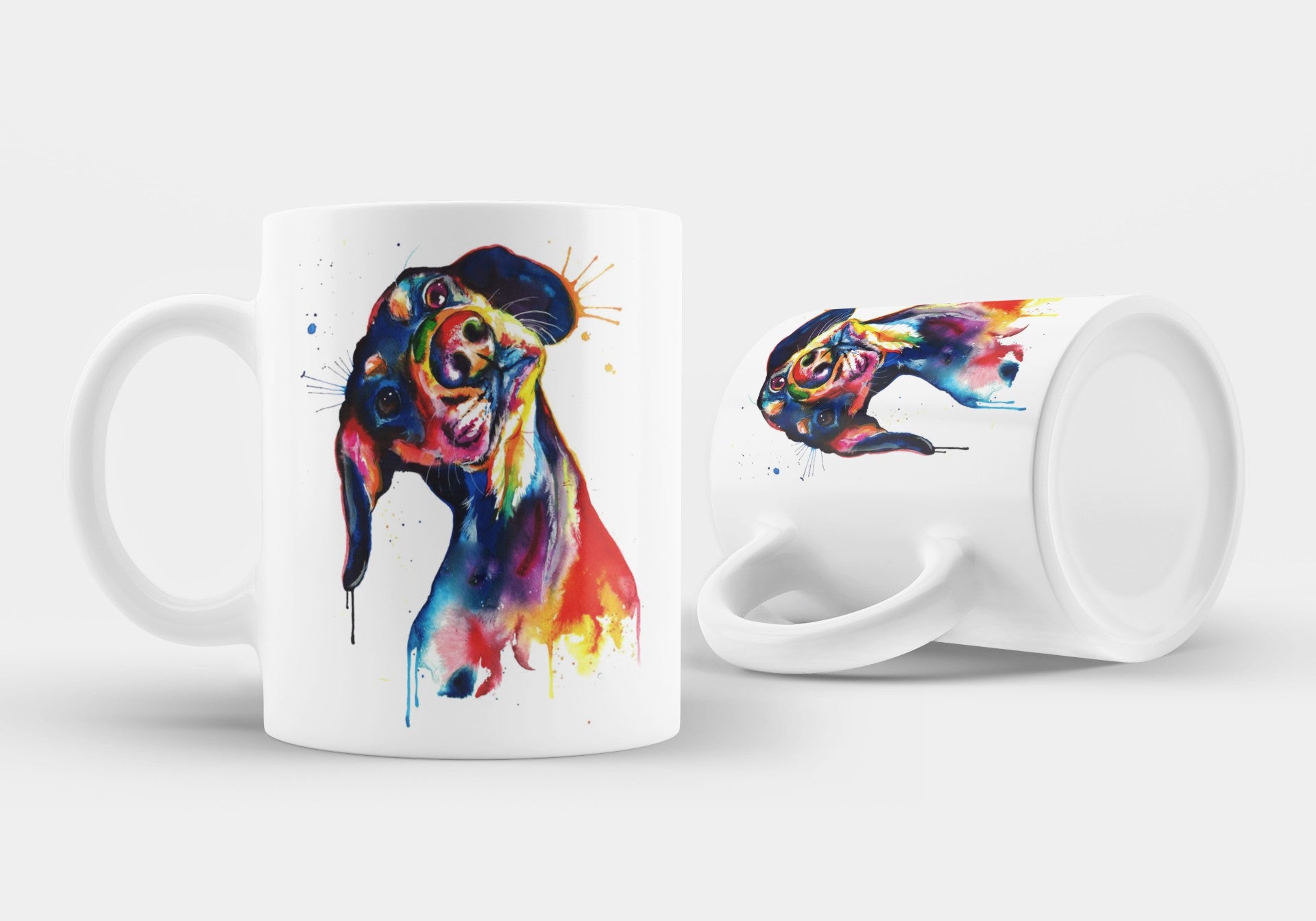 Two white mugs with colorful fish designs on a light gray background