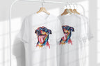Two white t-shirts with colorful dog illustrations on hangers against a white background