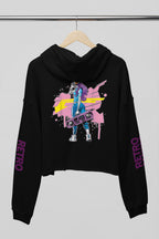 A black cropped hoodie hanging on a wooden hanger against a light gray background. The hoodie features a colorful graphic print on the front with a stylized figure and paint splatters, and the word 'RETRO' printed in purple down both sleeves.