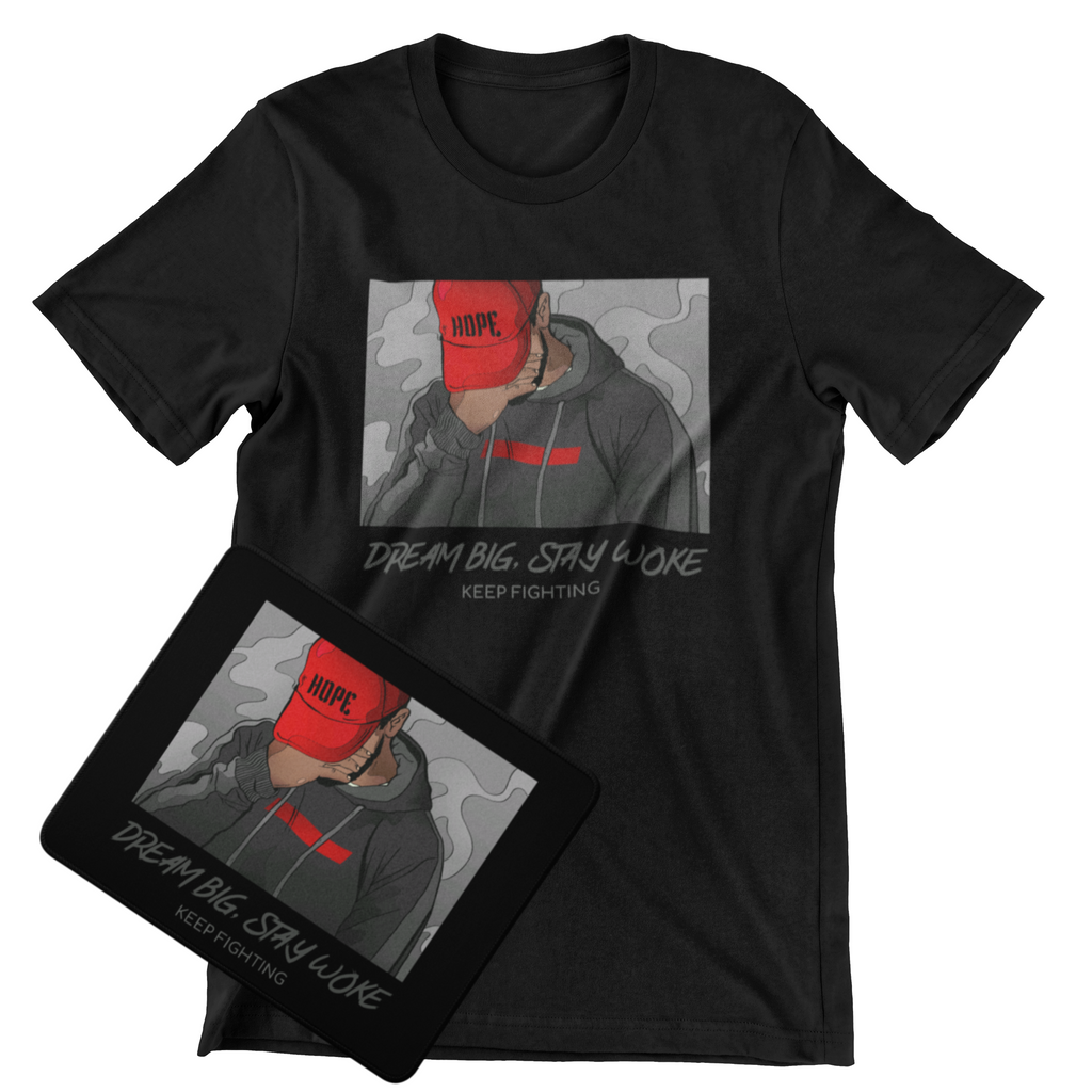 A black short-sleeve graphic T-shirt displayed on a white background, with a matching black rectangular print or card placed in front. The graphic shows a person in a gray hoodie wearing a red cap with the word HOPE, plus the text 'DREAM BIG.