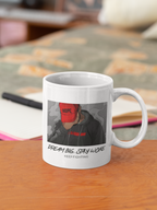 A white ceramic coffee mug with a printed graphic of a person wearing a red cap and the text 'DREAM BIG. STAY WOKE.