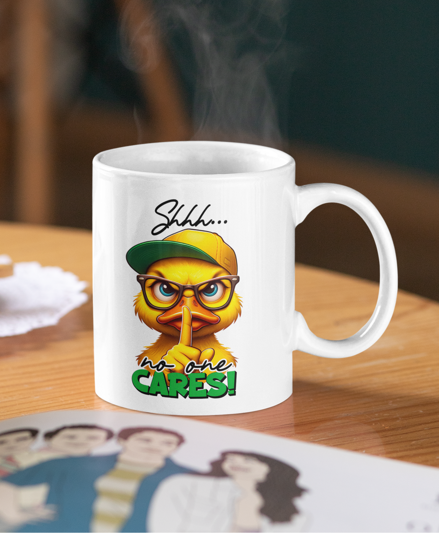 A white ceramic coffee mug with a cartoon duck graphic wearing a green cap and glasses, with the text 'Shhh.