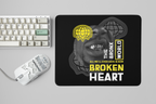 Mouse pad with graphic design featuring a face and text, placed on a desk with a keyboard and mouse.