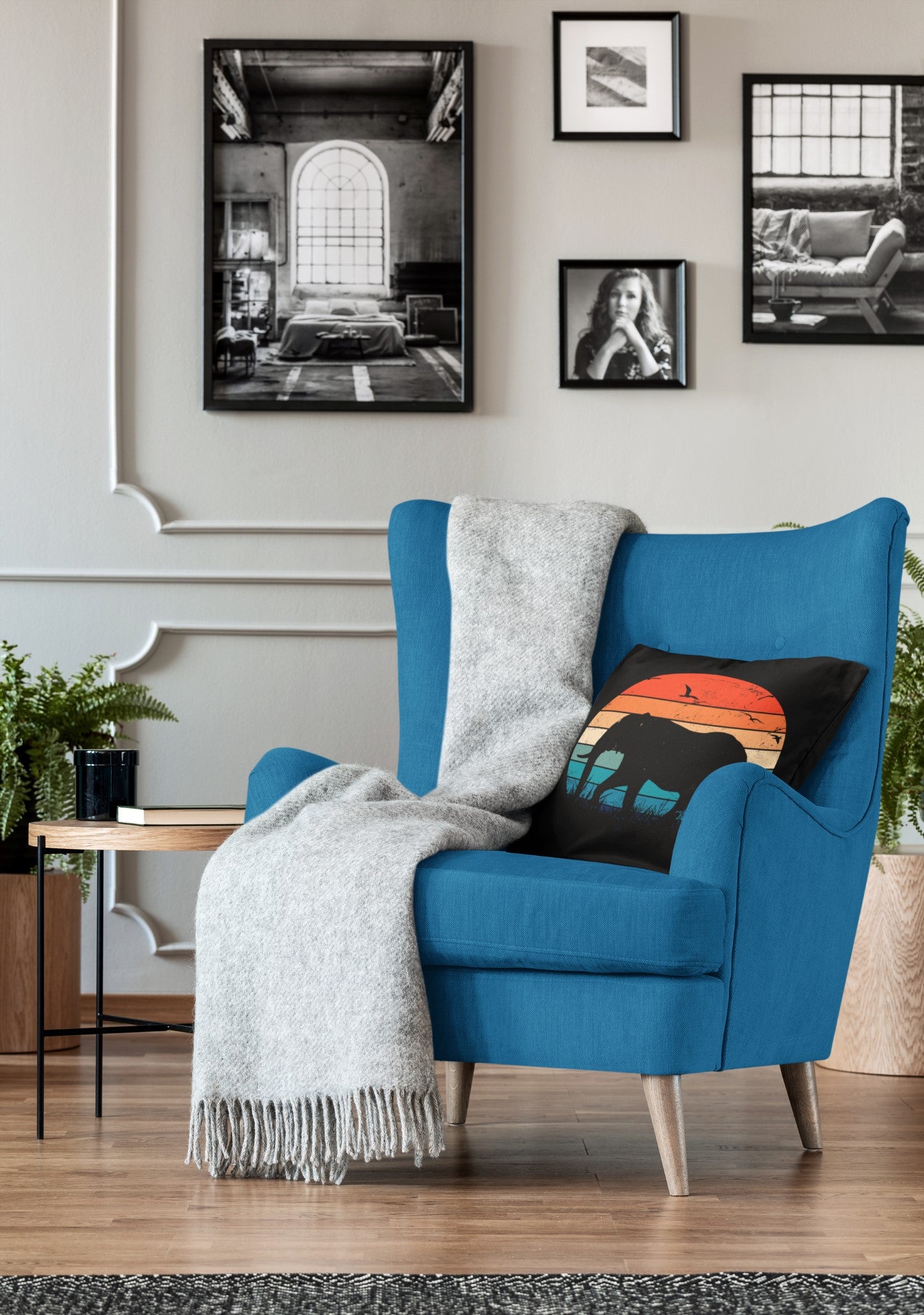 Blue armchair with a gray blanket and colorful pillow in a living room setting.