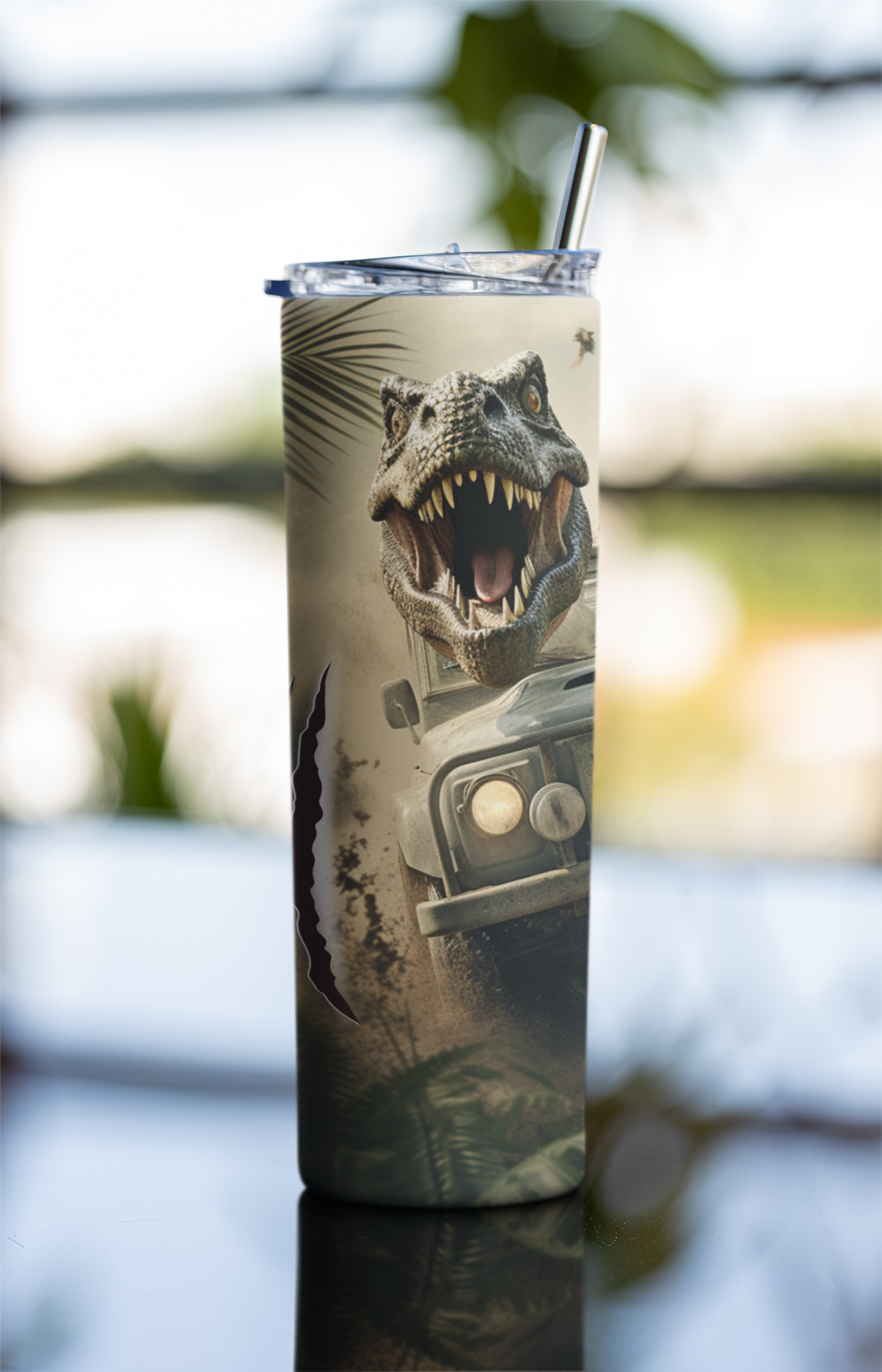 Tumbler with a dinosaur and car design on a blurred natural background