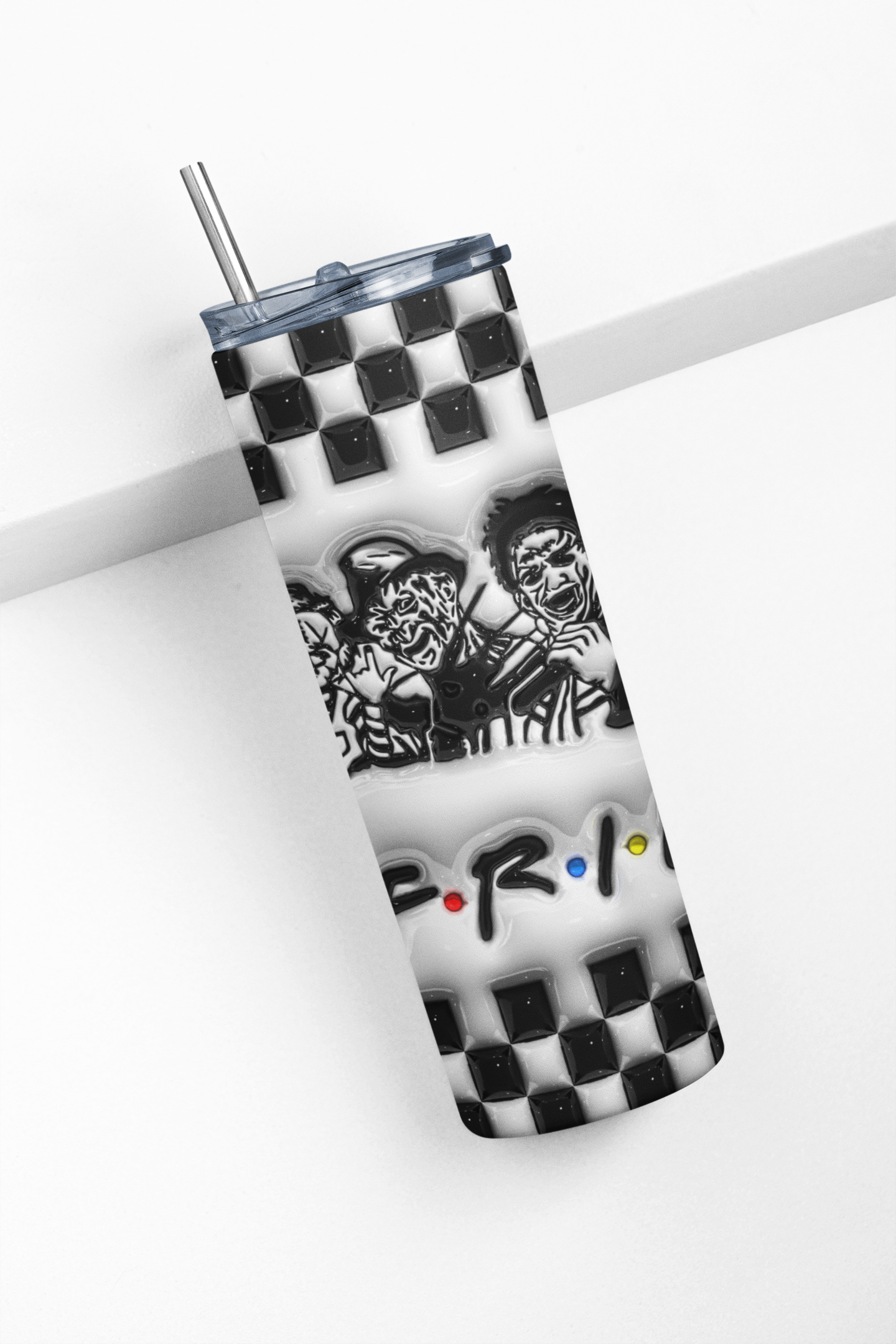 A tall insulated tumbler with a clear lid and metal straw, featuring a black-and-white checkerboard pattern, a black-and-white illustrated graphic, and the word 'FRI' with small red, yellow, and blue dots, shown on a white background.