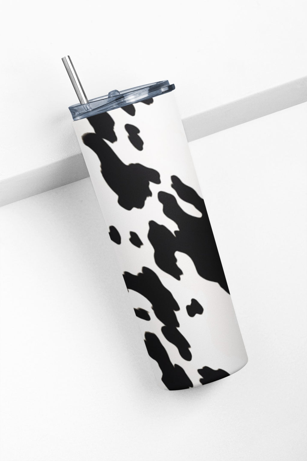 Tumbler with cow print design on a white background