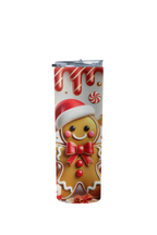 A tall, slim insulated tumbler with a festive Christmas gingerbread design, featuring a smiling gingerbread man wearing a Santa hat and red bow, with red candy canes and white icing drips on a white background.