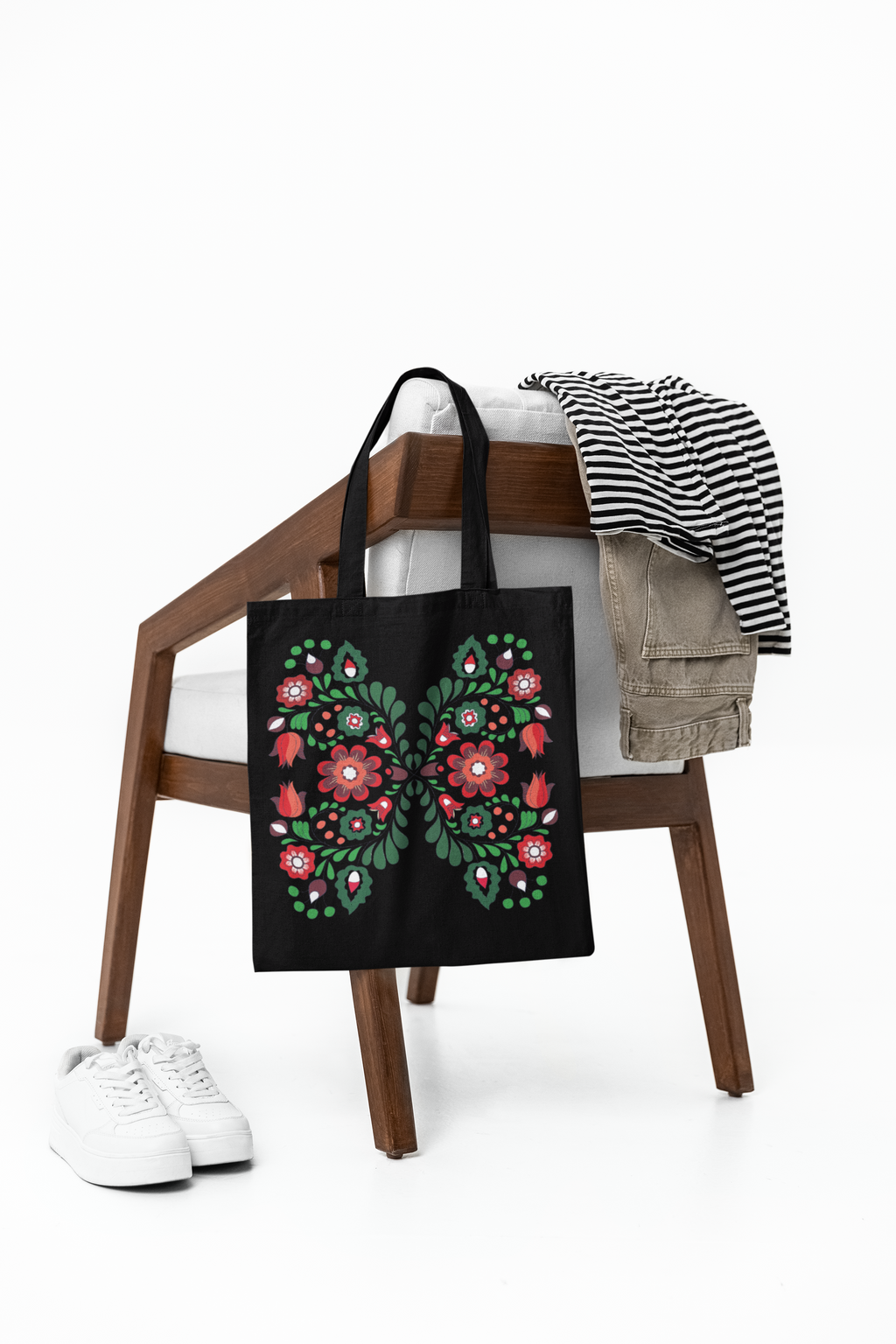 Tote bag with floral design on a wooden stool with clothes and shoes on a white background