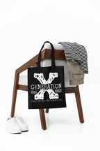 Black tote bag with 'Generation X' design on a wooden stool with clothes and shoes.