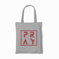 Gray tote bag with 'PRAY' printed in red on a white background