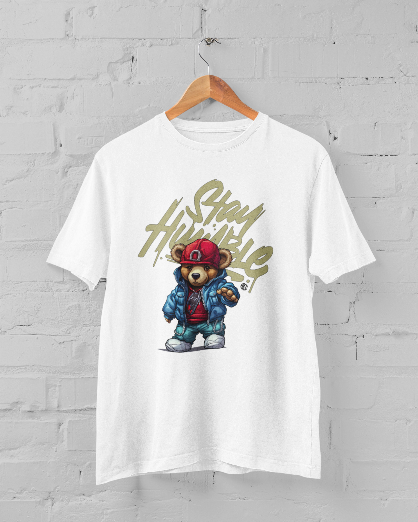 White t-shirt with a graphic of a bear in a jacket and 'Stay High' text on a gray brick wall background.