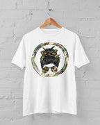 White t-shirt with a graphic design of a dog wearing sunglasses and a camouflage circle on a gray brick wall background.