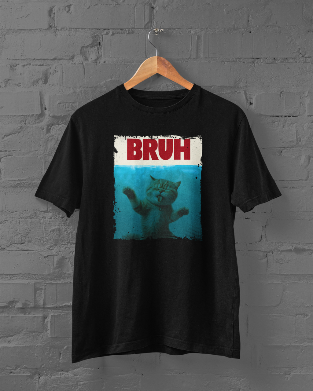Black t-shirt with a graphic of a cat and 'BRUH' text on a hanger against a brick wall.
