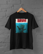 Black t-shirt with a graphic of a cat and 'BRUH' text on a hanger against a brick wall.