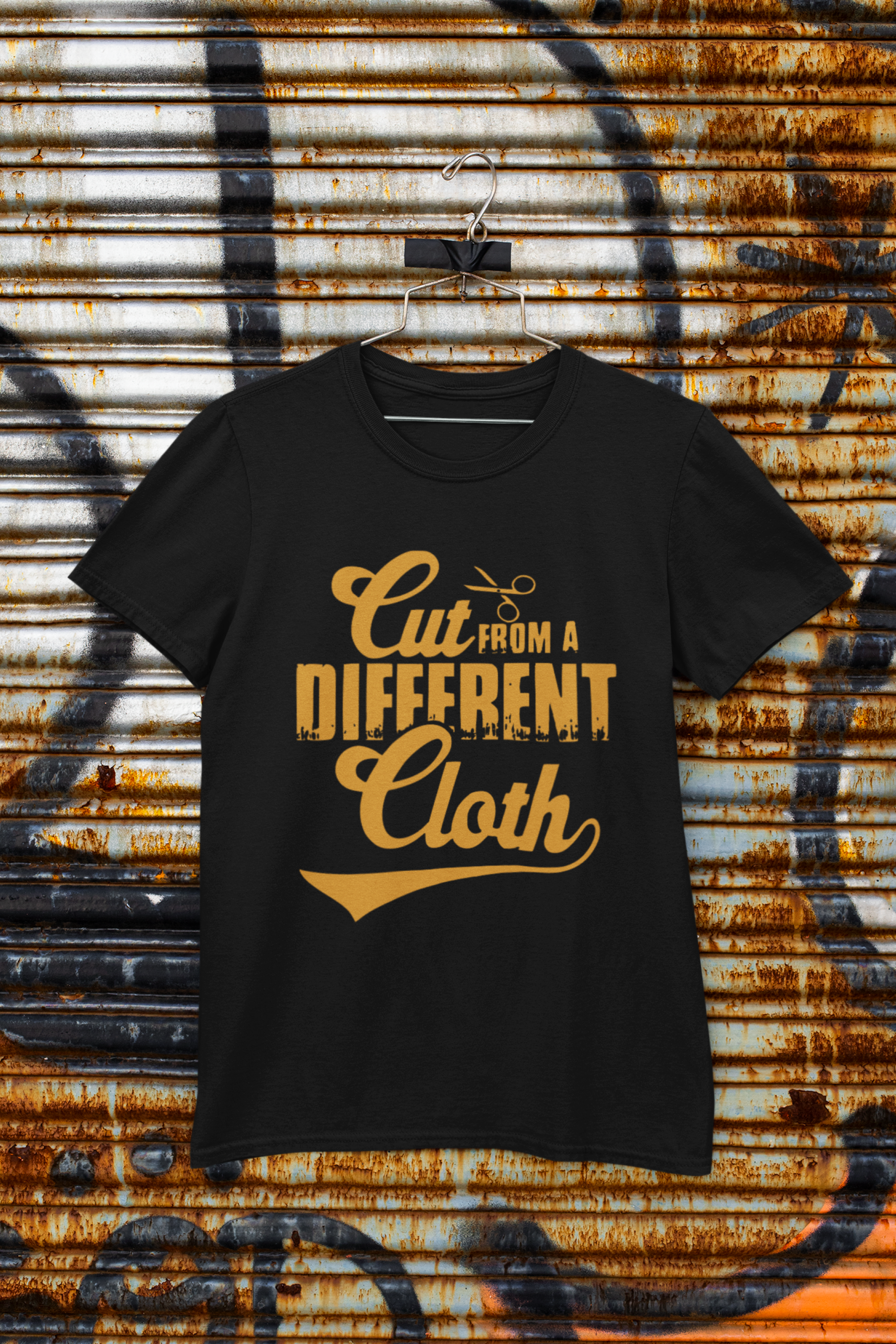 Black t-shirt with yellow text 'Cut from a Different Cloth' on a rusty metal background