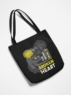 Black tote bag with graphic design and text on a white background