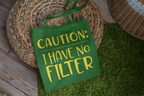 Green tote bag with 'CAUTION: I HAVE NO FILTER' text on a green surface.