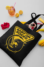 Black tote bag with 'Baby on Board' graphic, surrounded by lemon slices, a drink, sunglasses, and a scrunchie.