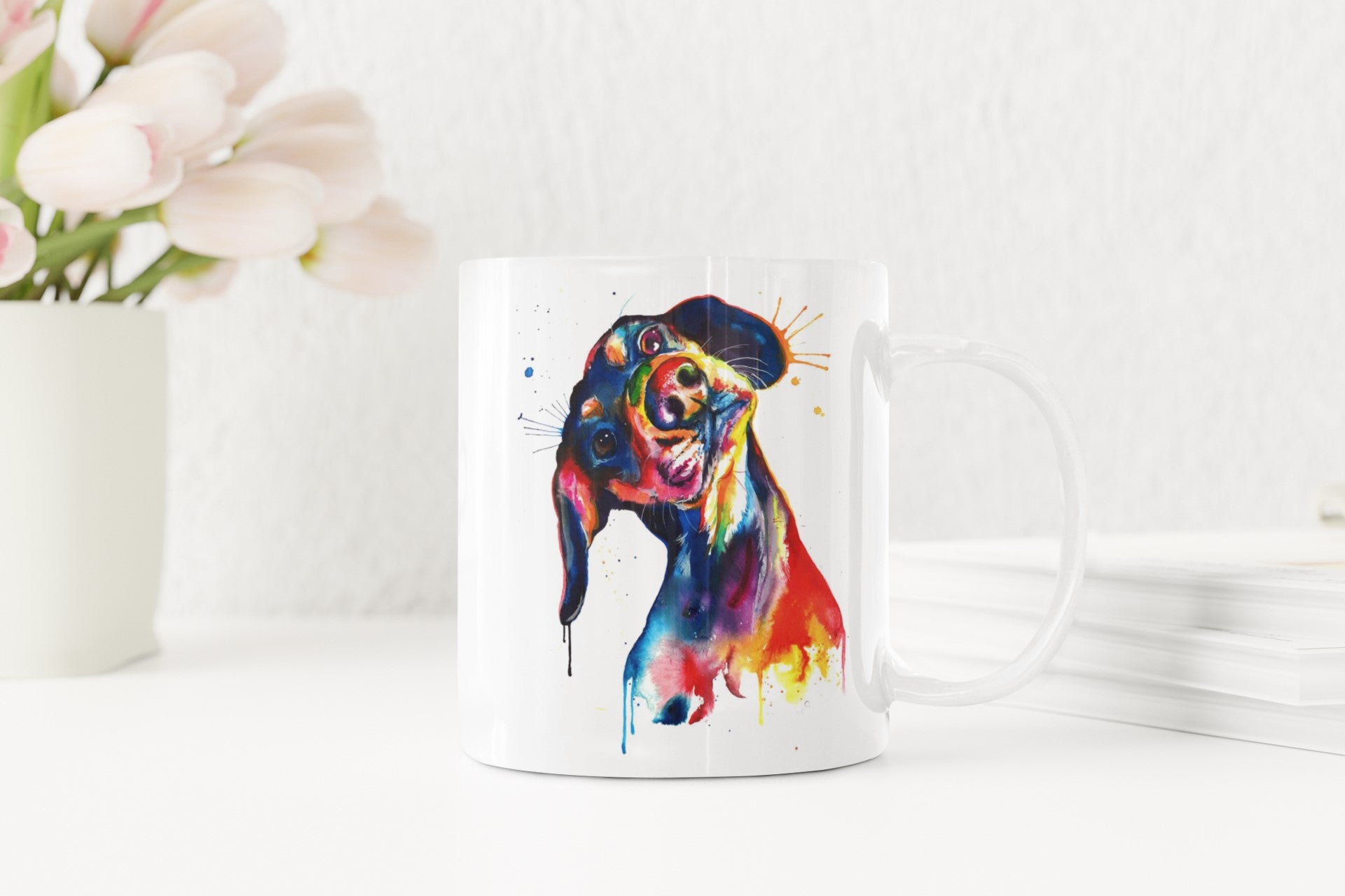 Colorful dog illustration on a white mug with flowers and plates in the background