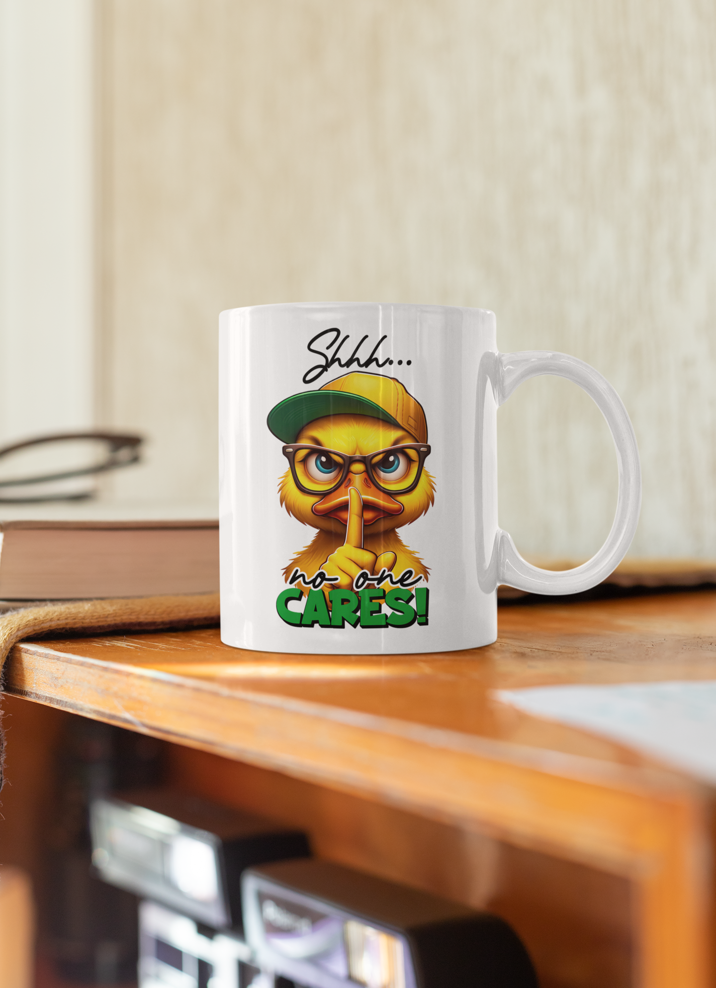 A white ceramic coffee mug with a cartoon bird wearing a green cap and glasses, with the text 'Shhh.
