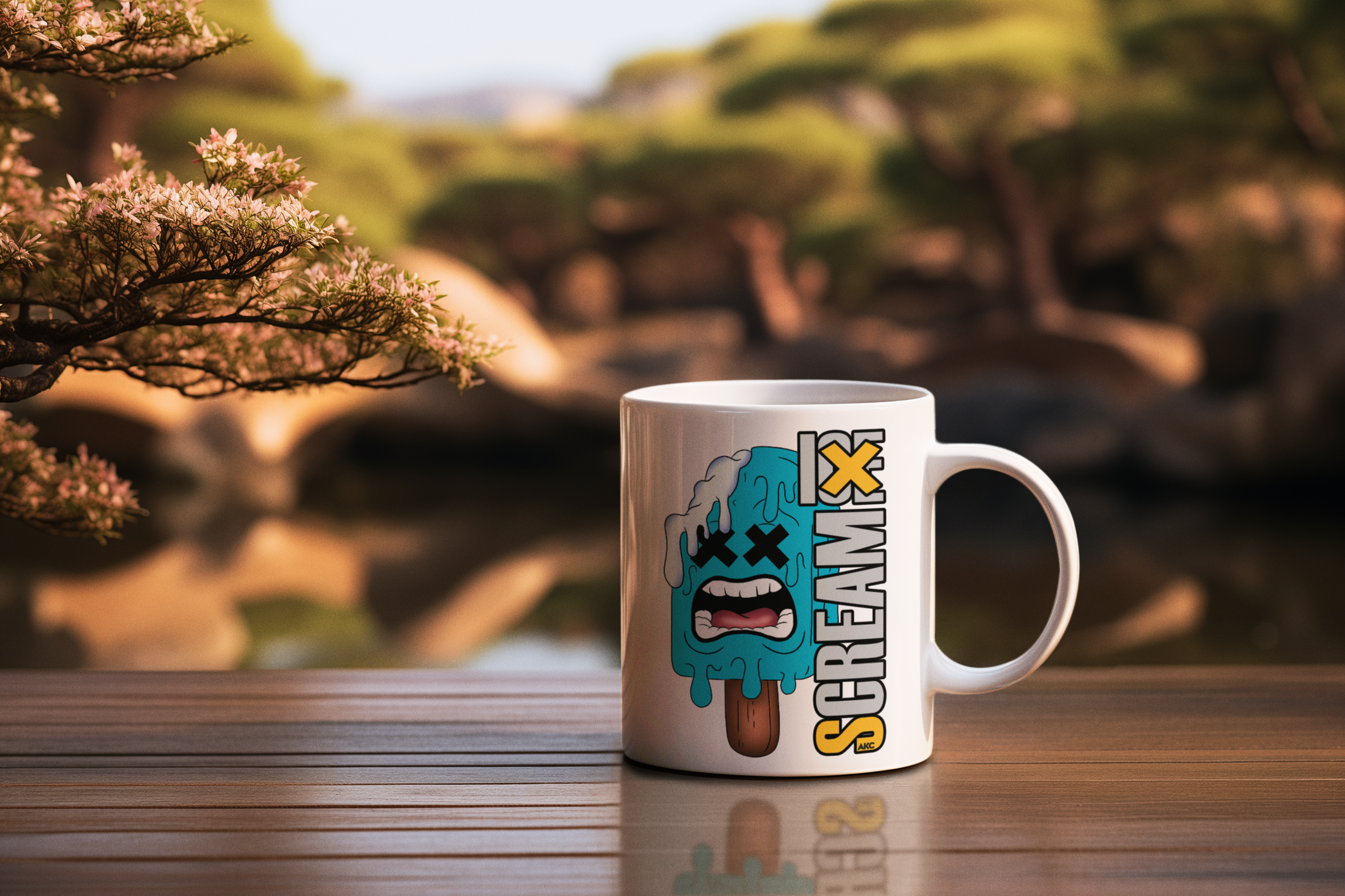 A white ceramic mug with a cartoon graphic of a crying, melting popsicle and the word 'SCREAMK' printed on it, set on a wooden table with a blurred outdoor garden background.