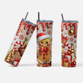 Three views of a tall insulated tumbler with a clear lid and black straw, printed with a festive Christmas design featuring a gingerbread man, candy canes, ornaments, gifts, and striped drips in red, gold, white, and brown on a light background.