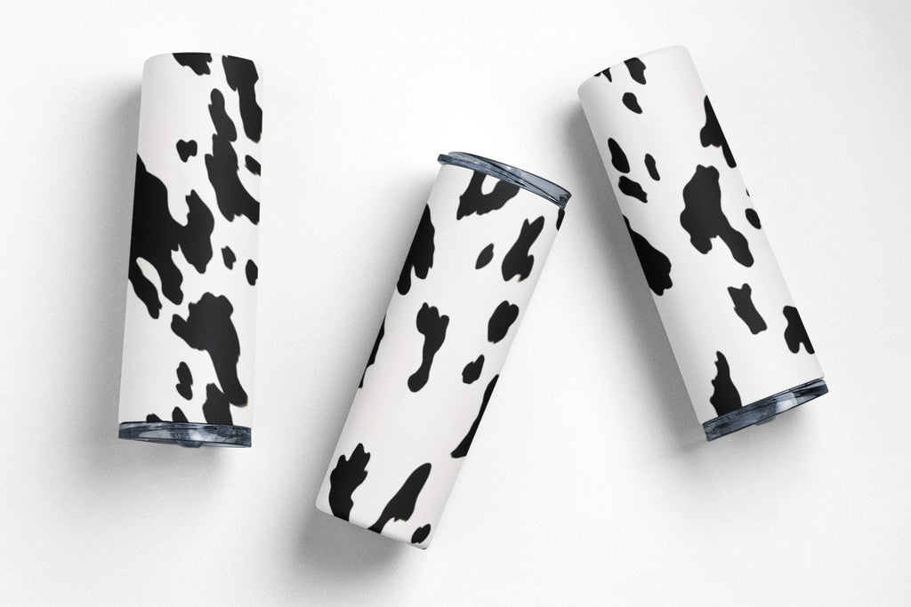 Four tumblers with cow print design on a white background