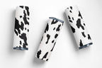 Four tumblers with cow print design on a white background